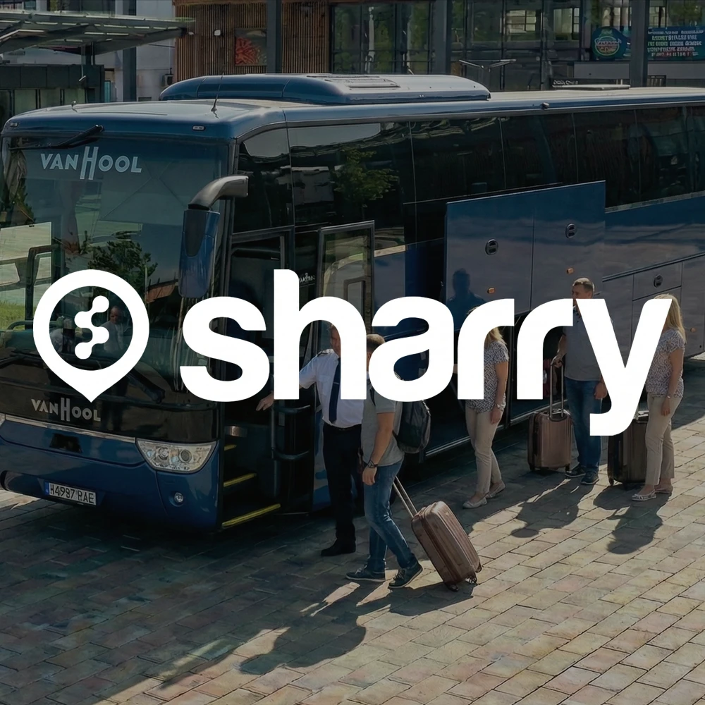 Sharry на фоні синього автобусу Vanhool, біля якого стоять пасажири